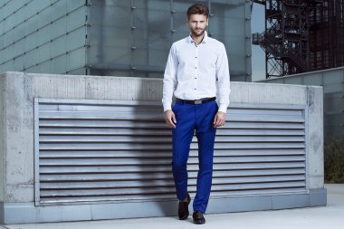 Bina arka plan üzerinde beyaz bir gömlek modeli adam