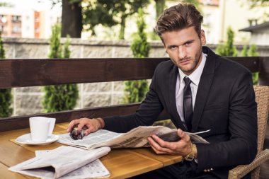 Siyah elbiseli bir gazete okuyor yakışıklı adam 