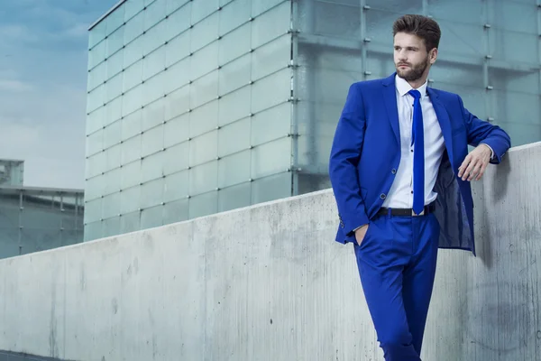 Schöner Mann im blauen Anzug auf dem Hintergrund der Stadt — Stockfoto