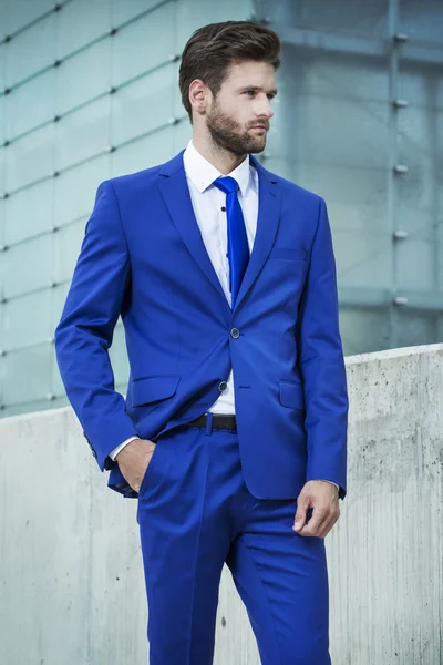 Hombre guapo en un traje azul en el fondo de la ciudad —  Fotos de Stock