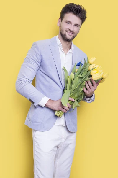 Hombre sosteniendo tulipanes amarillos — Foto de Stock