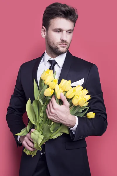 Homem segurando tulipas amarelas — Fotografia de Stock