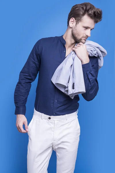 Handsome man in a dark blue shirt on a blue background — Stock Photo, Image