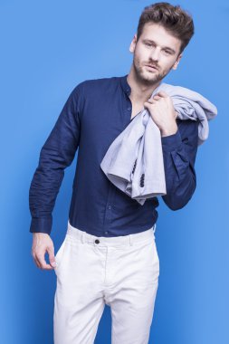 Mavi bir arka plan üzerinde koyu mavi gömlekli yakışıklı adam