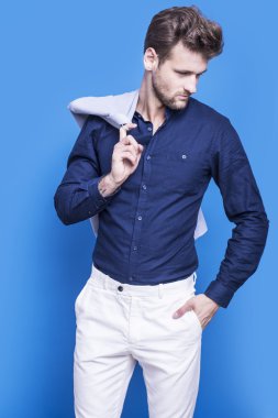 Mavi bir arka plan üzerinde koyu mavi gömlekli yakışıklı adam