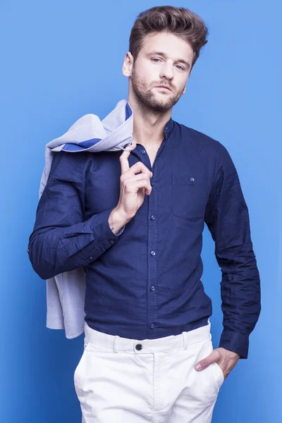 Schöner Mann in dunkelblauem Hemd auf blauem Hintergrund — Stockfoto