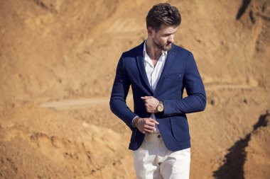 Yakışıklı bir adam çölde karşı koyu mavi ceket