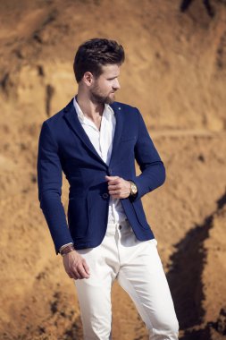 Yakışıklı bir adam çölde karşı koyu mavi ceket