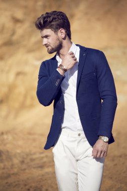 Giyinmiş yakışıklı adam zarif çölde yürürken