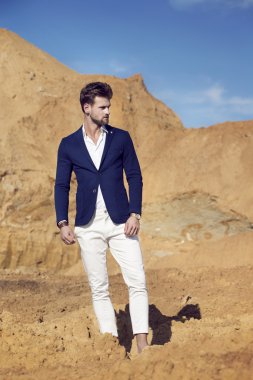 Giyinmiş yakışıklı adam zarif çölde yürürken