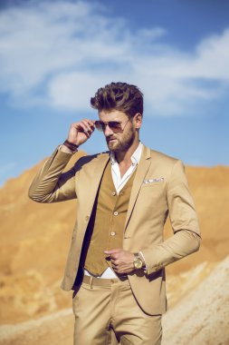 Giyinmiş yakışıklı adam zarif çölde yürürken