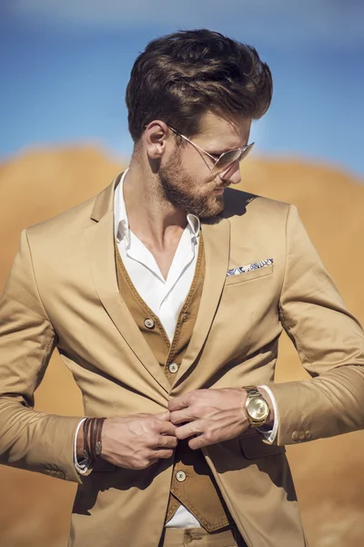 Schöner Mann elegant gekleidet beim Gang durch die Wüste — Stockfoto
