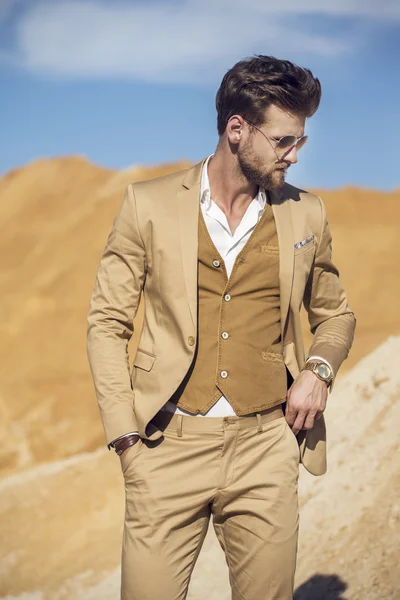 Schöner Mann elegant gekleidet beim Gang durch die Wüste — Stockfoto
