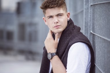 Otopark ve şehrin arka plan üzerinde yakışıklı bir genç adam portresi