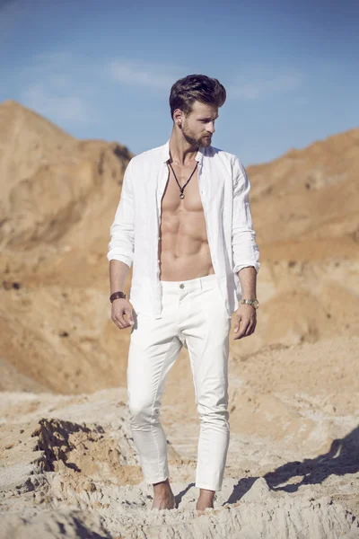 Handsome sexy man in the desert — Stock Photo, Image
