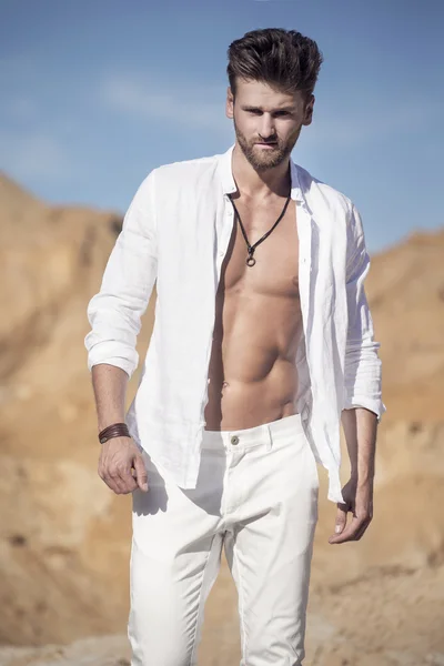 Handsome sexy man in the desert — Stock Photo, Image