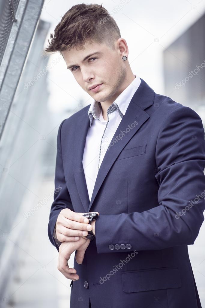 Young handsome man in a blue suit against the city