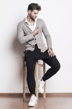 yakışıklı bir adam bir sandalyede oturuyor