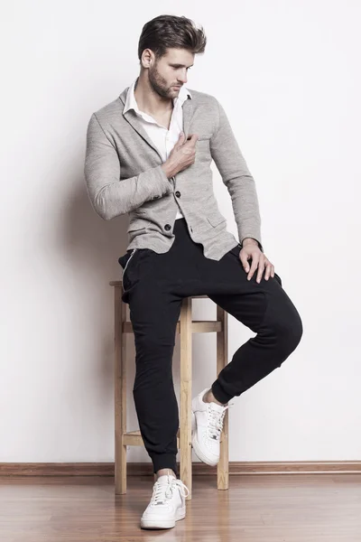 yakışıklı bir adam bir sandalyede oturuyor