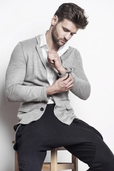 yakışıklı bir adam bir sandalyede oturuyor