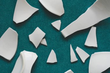 Kırık beyaz kapların kıymıkları ve parçaları. Kırık tabak, cam. Parçalanmış tabak parçaları. Yakın çekim, üst görünüm