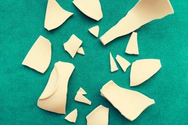 Kırık beyaz kapların kıymıkları ve parçaları. Bir aile kavgasının metaforu. Kırık tabak, cam. Mutfaktaki kaza kavramı. Parçalanmış tabak parçaları.. 