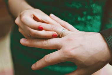 Damat yüzük gelini giyer. Bir kadın adama bir yüzük takıyor. Nişan.