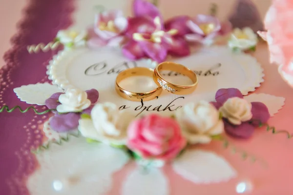 Engagement ring at the wedding. Rings lie on the marriage certificate — Stock Photo, Image