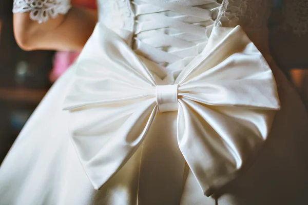 Trouwjurk wordt vastgebonden op terug uitvoerig close-up. omhoog knoop bruiloft jurk — Stockfoto