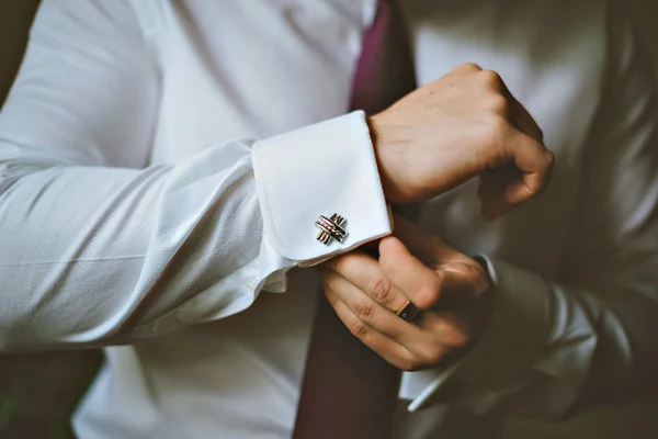 Primer plano de un hombre de la mano cómo lleva camisa blanca y gemelo —  Fotos de Stock