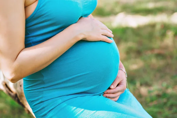 Femme enceinte avec les mains serrant son estomac — Photo