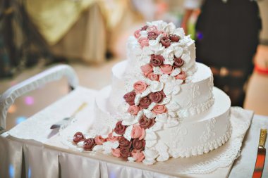 Bir gelin ve damat onların düğün pastası mor ve beyaz çiçekler ile kesme