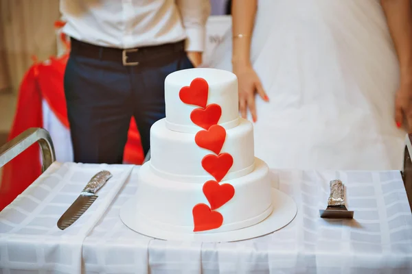 Bride and Groom at Wedding Reception Cutting the Wedding Cake with hearts — Stock Photo, Image