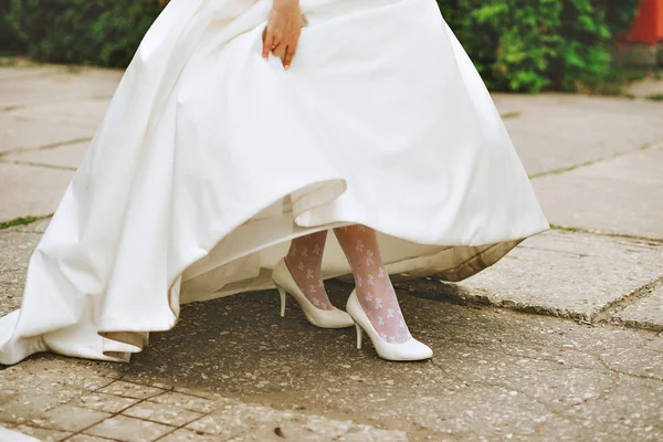 新娘的女人腿穿红色高跟鞋，坐在车里，专注于鞋 — 图库照片#