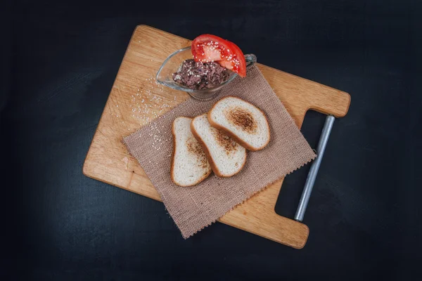 Pate vejetaryen fasulye domates ile. Sebze sandviç. Slate üzerinde snack. Kızarmış ekmek. Susam siyah bir zemin üzerine beyaz ekmek. Ahşap arka plan Snacks.