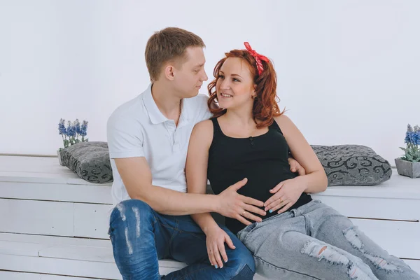 Un jeune homme et une jeune belle femme se regardent. En prévision du bébé. Une femme enceinte. Les futurs parents . — Photo