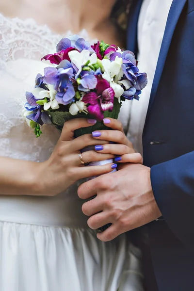 아름다운 연인 쌍의 신혼 부부는 숲에서 포옹. 흰색 라일락 보라색의 꽃다발을 들고 있는 손 — 스톡 사진