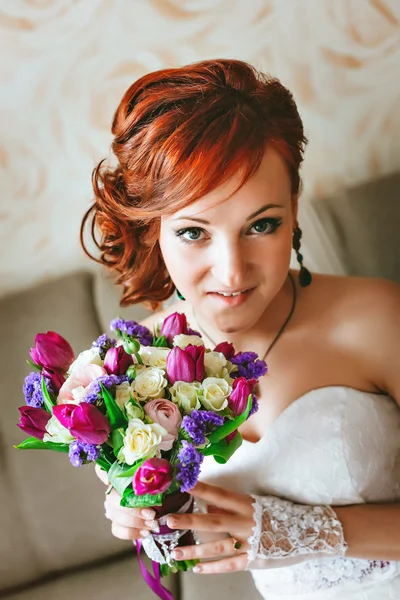 紫ピンクの花束を持って若い美しい花嫁。赤髪。カメラを見てください。 — ストック写真