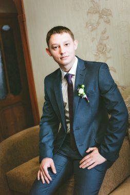 Kanepede oturan mavi elbiseli genç damat portre