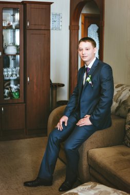 Kanepede oturan mavi elbiseli genç damat portre