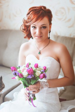 Mor pembe buket tutan genç güzel gelin. Kızıl saçlı. Kameraya bakarak