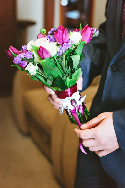 Fialová, růžová, bílá svatební kytice květiny v rukou mužů. — Stock fotografie