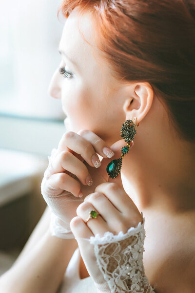Earrings with green gemstone. Beautiful jewelry. Aged gold.