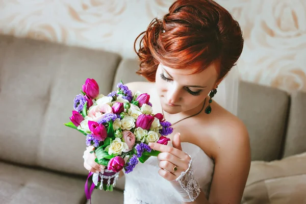 紫ピンクの花束を持って若い美しい花嫁。赤髪。花を見てください。 — ストック写真