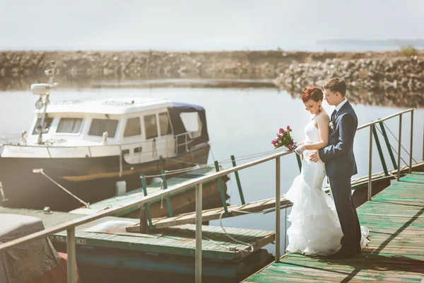 Porträtt av lyckliga älskande par, nära stranden, smile, kommunicera, skratta. I händerna brudbukett med vita, lila, rosa blommor. — Stockfoto