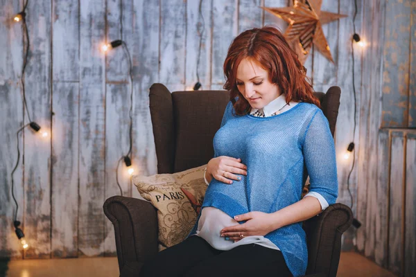 Jeune femme enceinte en tenue bleue. Cheveux roux. Souriant joyeusement — Photo