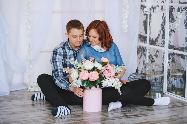 Pareja joven embarazada enamorada. El marido abraza a su esposa. Con colores de cuarzo rosa y azul cielo . — Foto de Stock