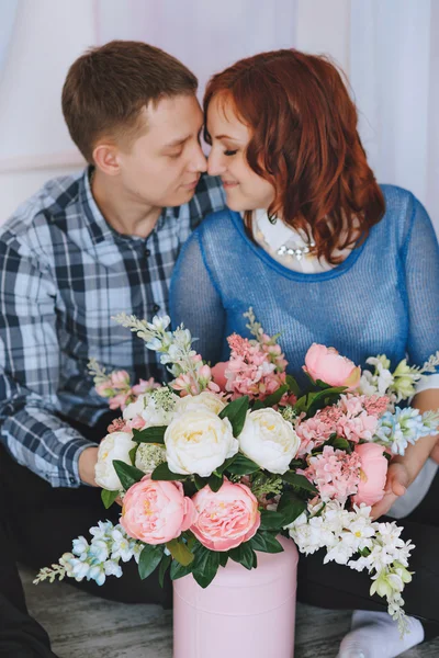 Pareja joven embarazada enamorada. El marido abraza a su esposa. Con colores de cuarzo rosa y azul cielo . — Foto de Stock