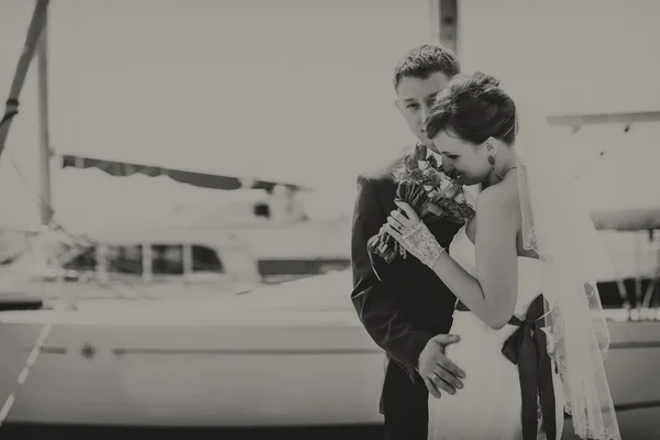 Het paar in de haven, knuffelen elkaar, kijken naar boeket. Zwart-wit fotografie. — Stockfoto