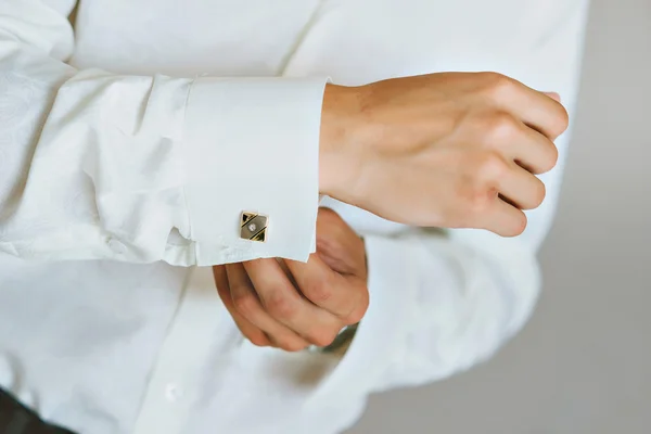 Primer plano de un hombre de la mano cómo lleva camisa blanca y gemelo — Foto de Stock